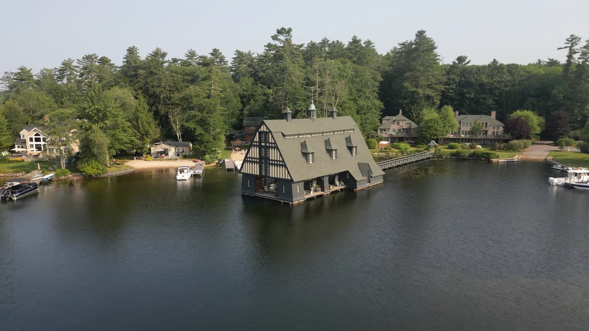 Aerial drone view of Tudor-style boathouse on a New England lake